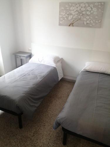 a bedroom with two beds and a painting on the wall at CA12 casa vacanze in Putignano