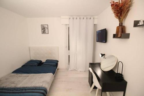 1 dormitorio con 2 camas y escritorio con escritorio en Bel appartement meublé 4 pièces, en Ris-Orangis