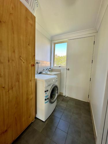 a laundry room with a washing machine and a window at Sunrise Villas by Charlesworth in Scotts Head