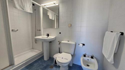 a white bathroom with a toilet and a sink at Karma loft en la playa in Sanlúcar de Barrameda