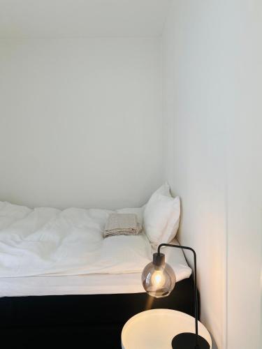 1 dormitorio con 1 cama y 1 mesa con lámpara en Leilighet ved Slottsfjellet, en Tønsberg