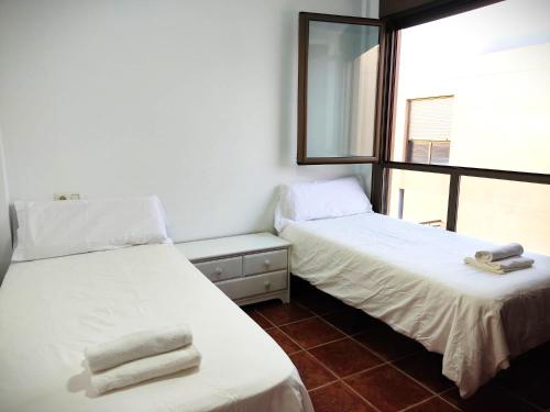 two beds in a room with a window at Villa Brisita in Granadilla de Abona