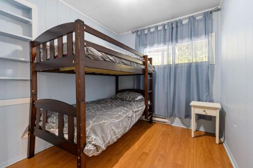 une chambre avec un lit superposé et une fenêtre dans l'établissement Chalet chaleureux avec spa près de Mont-Tremblant, à Namur