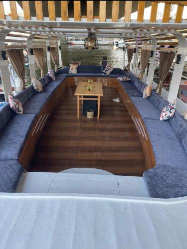 a room on a boat with a table in the middle at Nile Boat in Cairo