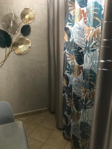 a wall with a curtain with leaves on it at LA PAILLOTE D OR in Sainte-Anne