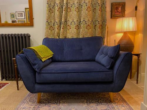 eine blaue Couch im Wohnzimmer in der Unterkunft Enchanting 1 Bedroom Home with Kitchen in Saffron Walden