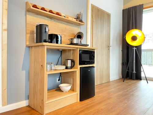 a kitchen with a shelf with a microwave and a stove at Suite zwischen den Wehlen in Westerdeichstrich