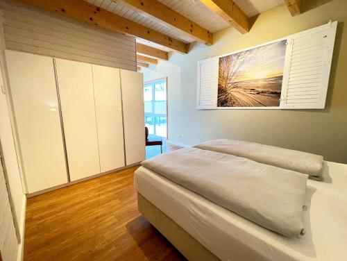 a bedroom with a bed and a painting on the wall at Suite zwischen den Wehlen in Westerdeichstrich