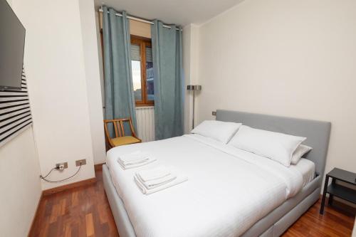 1 dormitorio con cama blanca y ventana en Apartment Forum IV, en Assago