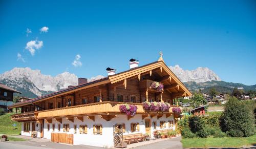 a large wooden house with flowers on the roof at Haus Strobler in Going