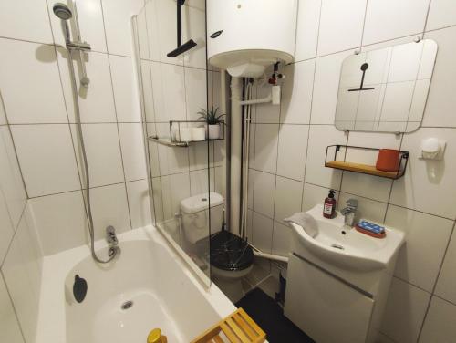 a bathroom with a tub and a toilet and a sink at Cosy Studio à proximité de PARIS in Savigny-sur-Orge