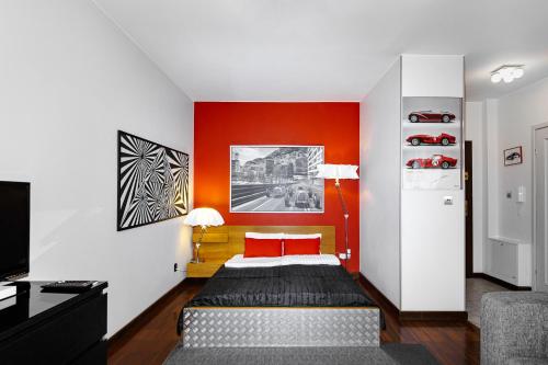 Un dormitorio con una pared de acento rojo y una cama en Aura Apartment, en Wroclaw