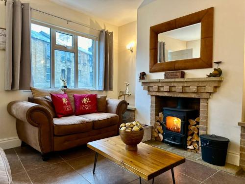 a living room with a couch and a fireplace at Fallow Cottage, 3 Bedrooms, Woodburner - Heart of Stamford by Belmont Places in Lincolnshire