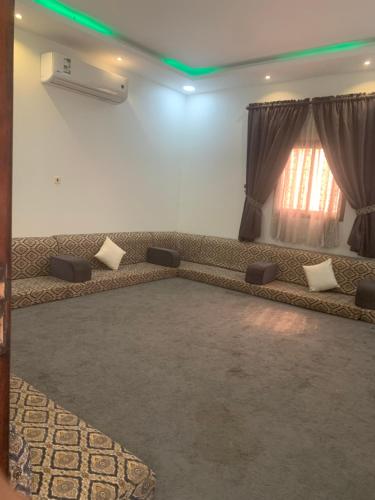 uma sala de estar com um sofá e uma janela em شاليه لمه em Dammam