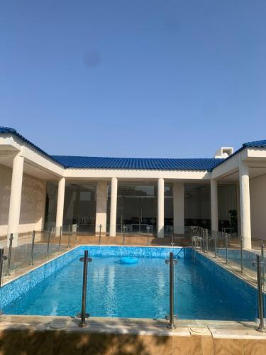 une grande piscine en face d'un bâtiment dans l'établissement شاليه لمه, à Dammam