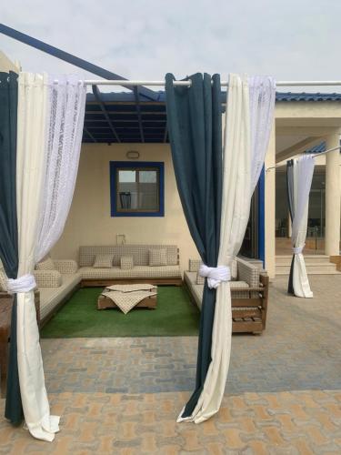 salon z zasłonami i kanapą w obiekcie شاليه لمه w mieście Dammam