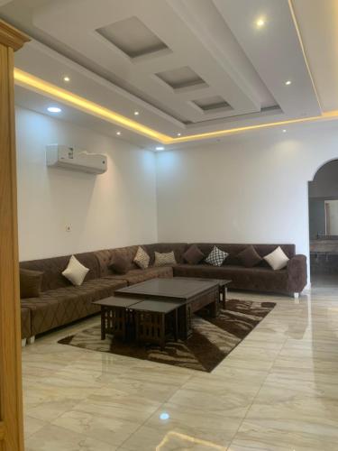 sala de estar con sofá y mesa de centro en شاليه لمه, en Dammam