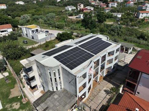 ein Gebäude mit Sonnenkollektoren darüber in der Unterkunft Apartments DEA in Bar