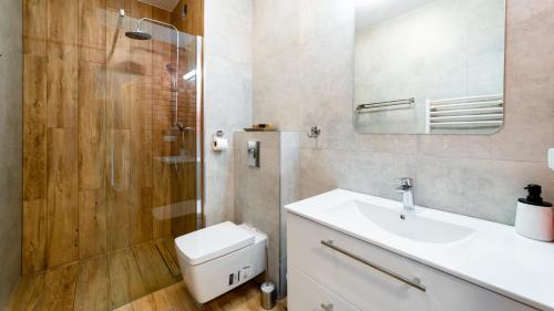 een badkamer met een toilet, een wastafel en een douche bij Apartament w Triventi Mountain Residence in Karpacz
