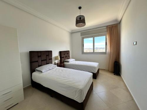 a bedroom with two beds and a window at Riverside 2 in Tetouan