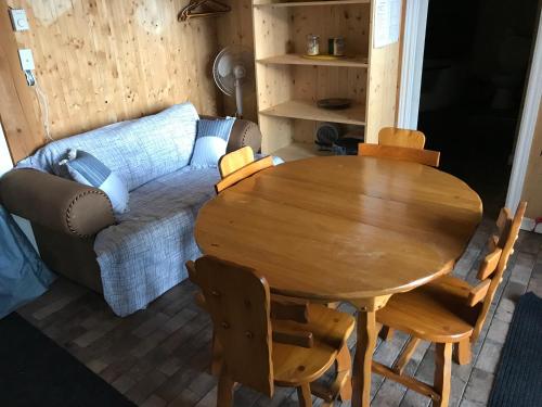 a living room with a wooden table and a couch at Le gîte du Lac à la Tortue in Herouxville