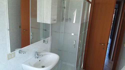 La salle de bains blanche est pourvue d'un lavabo et d'un miroir. dans l'établissement Casa Nina, à Borgo a Giovi