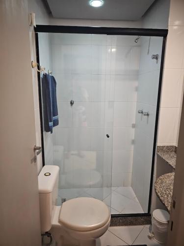 a bathroom with a toilet and a glass shower at Apto Barra Olímpica in Rio de Janeiro