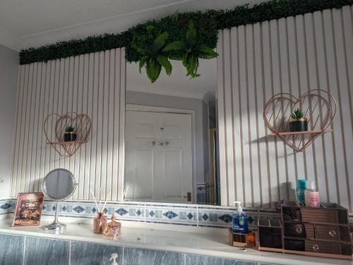 uma casa de banho com um espelho grande e um lavatório em FINN VILLAGE "Raspberry Cottage" Private Garden, 6-seater Hot Tub, Firepit & Pizza Stove em Glasgow