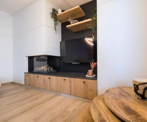 a kitchen with a counter with a tv and a table at Hotel Ter Streep in Ostend