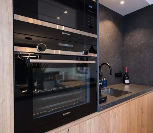 a black oven in a kitchen with a sink at Hotel Ter Streep in Ostend