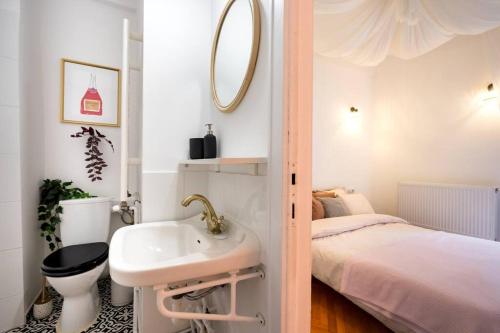 uma pequena casa de banho com um lavatório e uma cama em Downtown Cozy Apartment Old Town em Bucareste