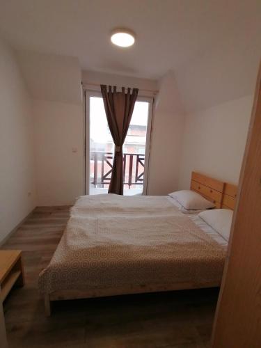 ein Schlafzimmer mit einem großen Bett und einem Fenster in der Unterkunft Gondola 22 in Kopaonik