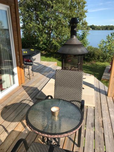 a table and chairs on a deck with a lamp at Le gîte du Lac à la Tortue in Herouxville