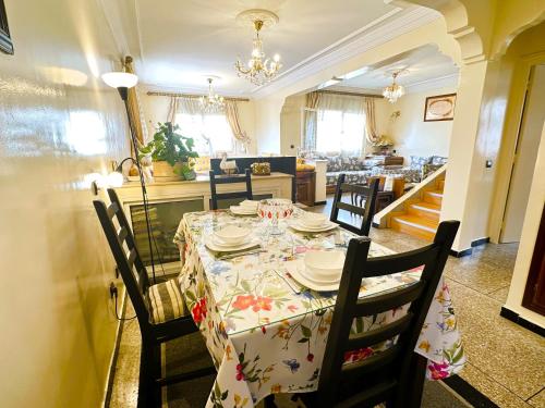 comedor con mesa con sillas y cocina en Spacieux et familial à 2 minutes à pied du stade de football de RABAT, en Rabat