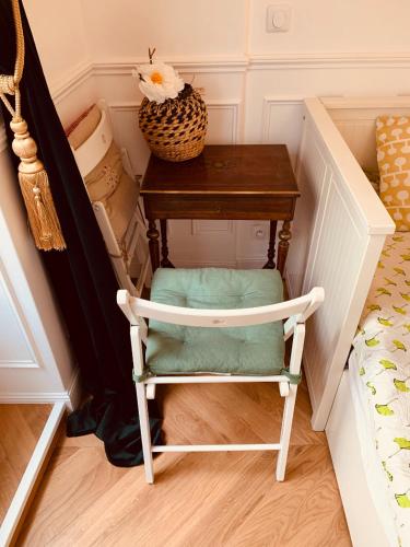 une chaise assise à côté d'une table à côté d'un lit dans l'établissement Parisian style Appartment Private room with Shared bathroom near Bastille and Gare de Lyon, à Paris