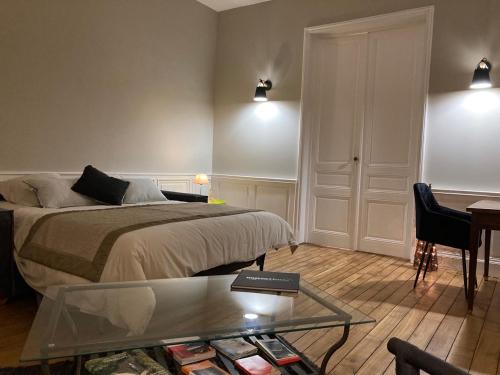 um quarto com uma cama e uma mesa de vidro em Golf & Rempart em Angoulême