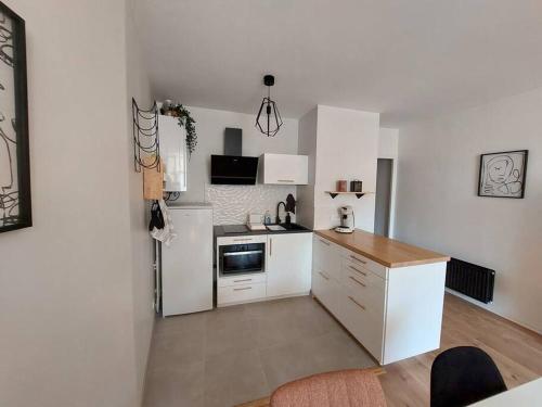 a kitchen with white cabinets and a stove top oven at L'arcade de Fontenay in Fontenay-le-Comte
