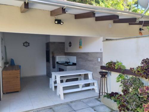 un patio al aire libre con mesa y banco en Residencial Annabel Apto 04, en Bombinhas