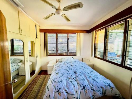 a bedroom with a bed in a room with windows at Private Holiday Home Malolo Island in Nadi