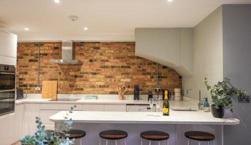a kitchen with a counter and a brick wall at Stunning Brighton Seaside 2-Bedroom Townhouse with Patio, Sleeps 6 in Brighton & Hove