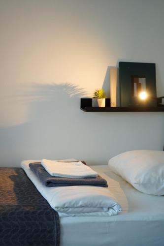 a bed with two pillows and a mirror on the wall at Inn Tourist Hostel in Helsinki