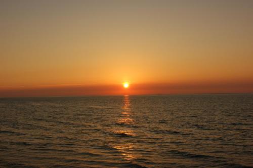 a sunset over the ocean with the sun setting at Hotel Villa A Mare in Rodi Garganico
