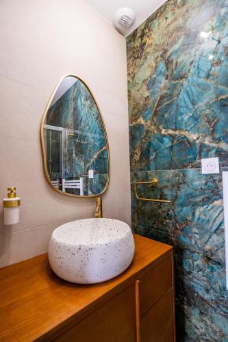 La salle de bains est pourvue d'un lavabo rond et d'un miroir. dans l'établissement Le Lodge, à Marseille
