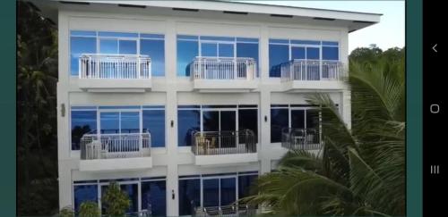 a large white building with balconies on it at Aundanao Oasis Beach in Samal