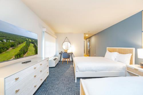 Habitación de hotel con cama y TV de pantalla plana. en The Inn at LBI National Golf & Resort, en Little Egg Harbor Township