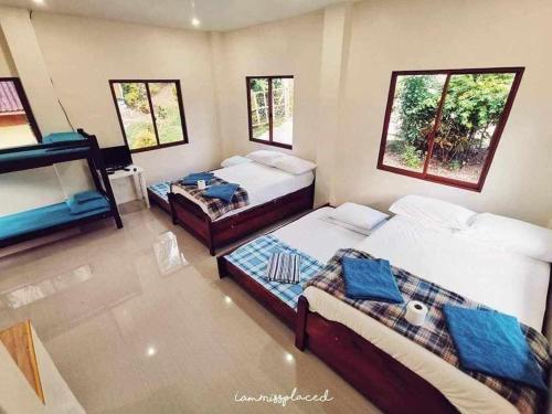 Habitación con 2 camas y 2 ventanas. en Aundanao Oasis Beach en Samal