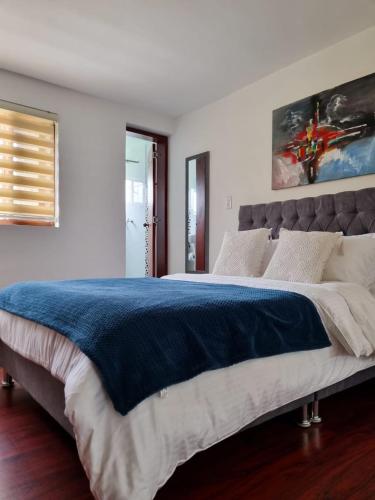 a bedroom with a large bed with a blue blanket at Florentina in Tunja