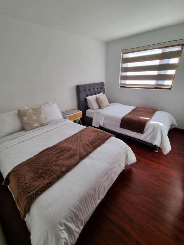 a bedroom with two beds and a window at Florentina in Tunja