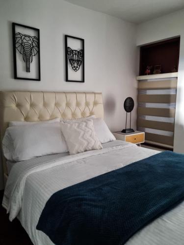 a bedroom with a large bed with two pictures on the wall at Florentina in Tunja