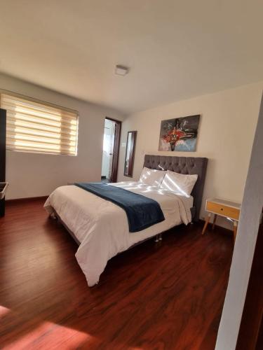 a bedroom with a large bed and a wooden floor at Florentina in Tunja